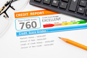 Credit score report with calculator, glasses and pencil on table
